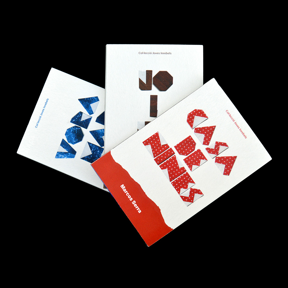 Tres llibres apilats, un blau, un marró i un vermell. Els títols estan fets amb lletres de paper origami.